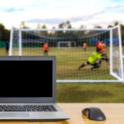 Laptop in front of football game